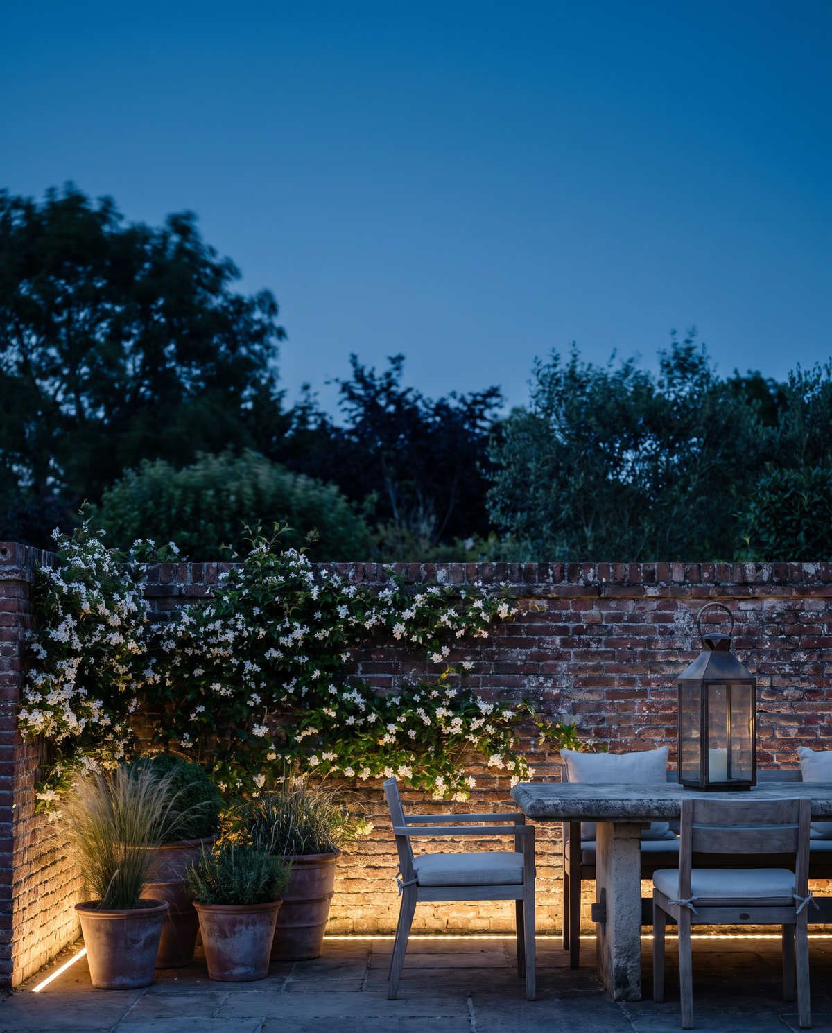 Walled garden courtyard glowing with warm light at dusk